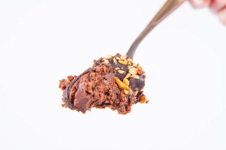 Rum ball decorated with chocolate and nuts on a white background