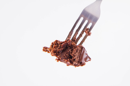 Chocolate cake eaten with a fork on a white backgroundの写真素材