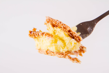 Napoleon cake - a Polish type of cream pie - sprinkled with powdered sugar, on a fork