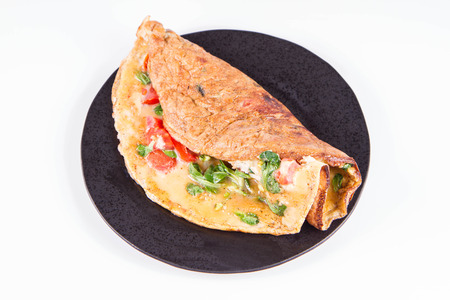 Omelette with tomatoes and fresh corn salad on a white backgroundの写真素材