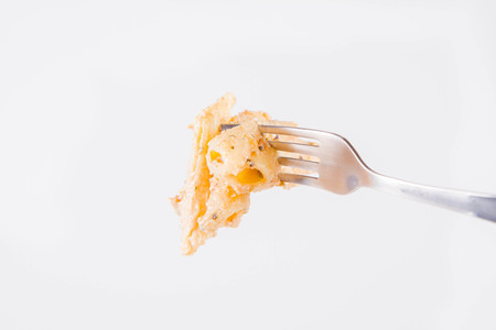 Pasta eaten with a fork - penne with cream sauce on a white background