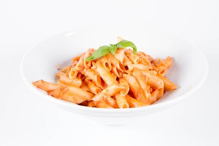 Penne with pesto rosso and sun dried tomatoes decorated with basilの写真素材