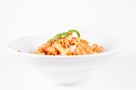 Penne with pesto rosso and sun dried tomatoes decorated with basilの写真素材