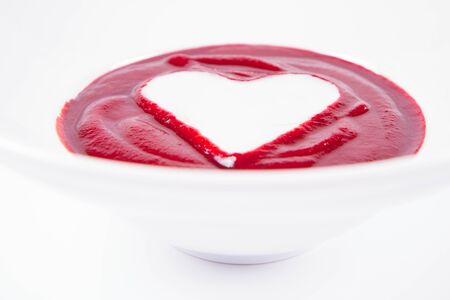 Beetroot cream soup decorated with a heart made of yoghurt