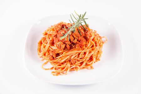 Spaghetti bolognese on a plate decorated with a rosemary twigの写真素材