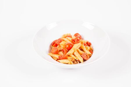 Penne with tomatoes, garlic and mozzarella on a white backgroundの写真素材