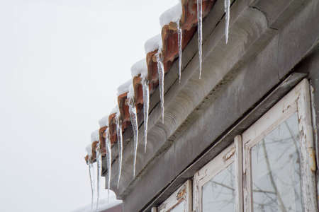Icicles hanging from a roof over a window