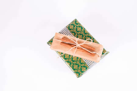 Gift wrapped in craft paper and tied with twine on white backgroundの写真素材
