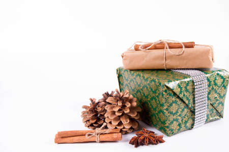Gift boxes wrapped in kraft paper and tied with twine, cinnamon and anise on a white background.の写真素材
