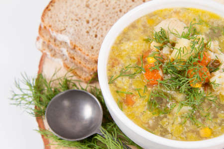 Vegetable and chicken soup with decorated with dill, served with fresh breadの写真素材