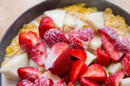 Healthy breakfast bowl with oat flakes, strawberries, melon and almonds