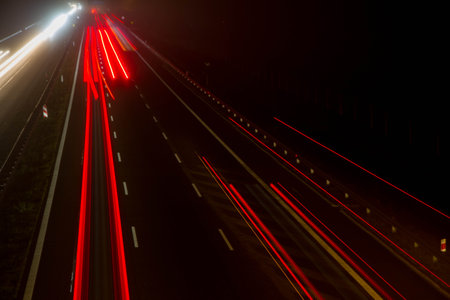 Car light trails at night on a highway seen downwards, long exposure