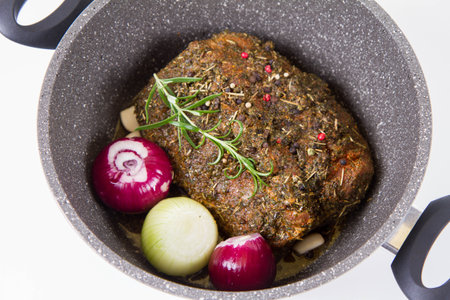 roasted meat with herbs and spices in a pan on a white backgroundの写真素材