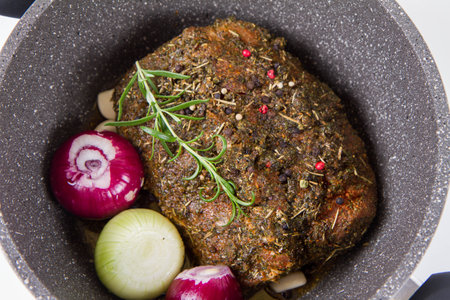 roasted meat with herbs and spices in a pan on a white backgroundの写真素材