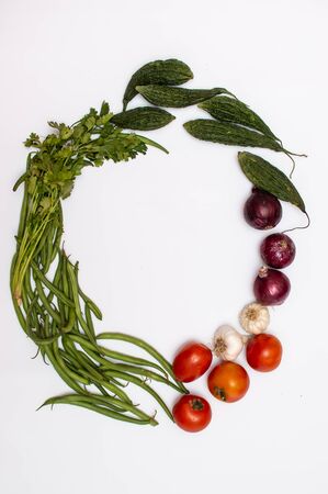 A bunch of vegetables and fruits placed in a circular position on a white backgroundの写真素材