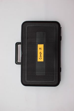 Corona virus kit showed by a orange strip on a black suit caseの写真素材