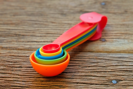 Colorful plastic measuring spoons on woodの写真素材