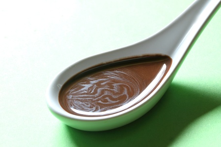 chocolate sauce on a porcelain spoonの写真素材