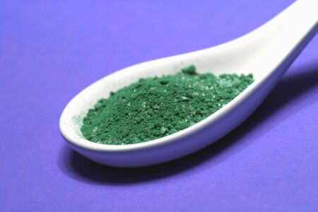 poisoned colored spice on a porcelain spoonの写真素材