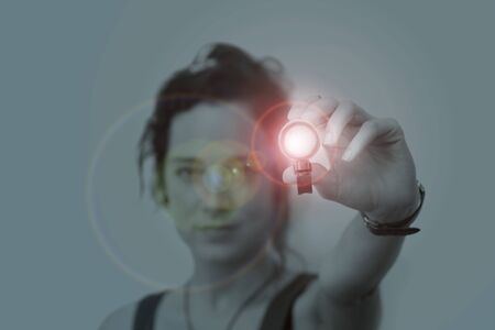 young woman holding a led flashlight at nightの写真素材