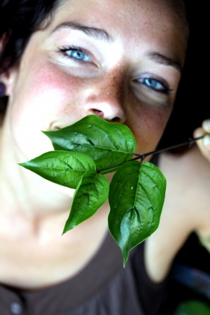 young woman with green foliageの写真素材