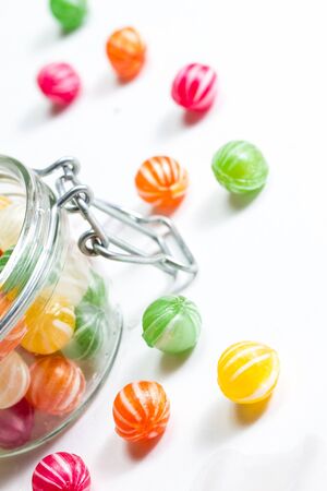 a selection of handmade colorful round candies in a glass vesselの写真素材