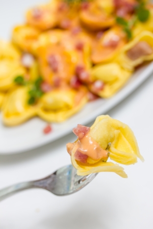 fresh tortellini in light sauce with hamの写真素材