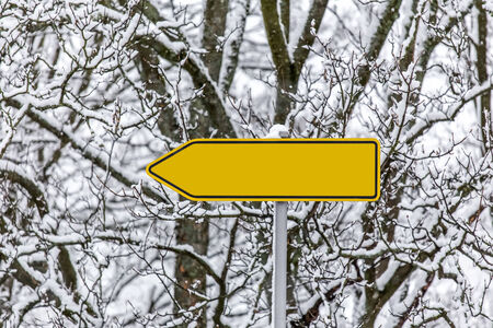 plain yellow arrow sign in the snow pointing leftの写真素材