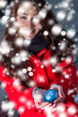 winter girl with a christmas sphere in the snowのeditorial素材
