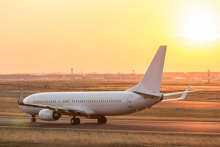 airplane on a starting runway evening sundownの写真素材
