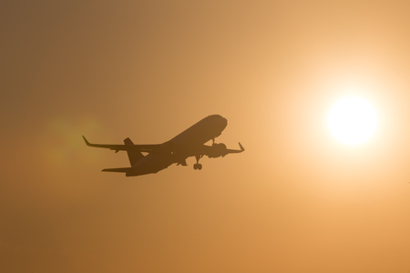 passenger airplane starting in the evening sunの写真素材