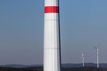 modern wind turbine column in front of the evening sunの写真素材