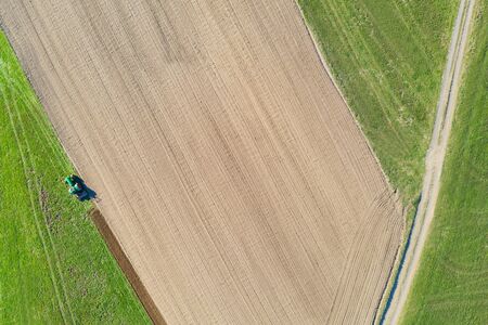 tractor digs a field from aboveの写真素材