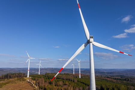 some wind wheels in front of a bright cloudscapeの写真素材