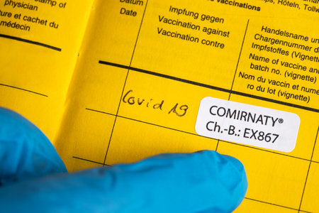 siegen, north rhine westphalia, germany - 06 05 2021: a biontech comirnaty sticker in an international who vaccination certificateのeditorial素材
