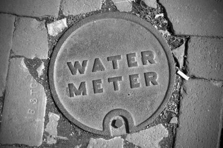 City Water Meter Lid on a cobblestone streetの写真素材