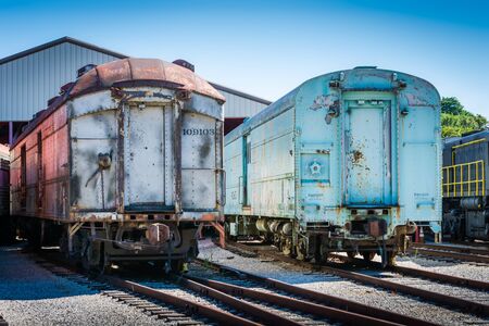 Two old train cars on rusty train tracks.の写真素材