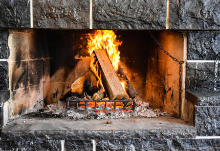 Fire flames in fireplace. Burning wood in fireplace in a countryside house. Close up. Warming and...