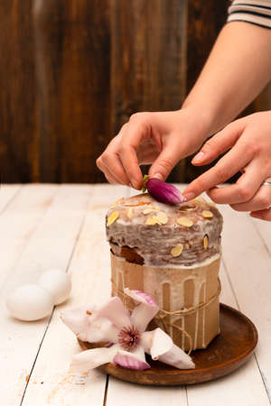 Woman decorated easter cake with flowers sugar and nuts.の写真素材