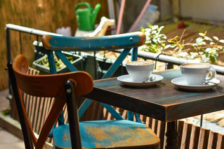 Two white cup with coffee on the blue vintage wooden table in cafe.の写真素材