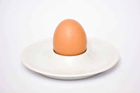 Egg in a white plate on a white background. Close-up.の写真素材