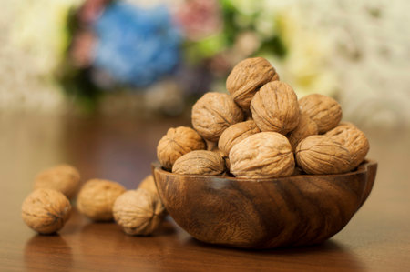 Walnuts in a wooden bowl on a wooden table. Selective focus.