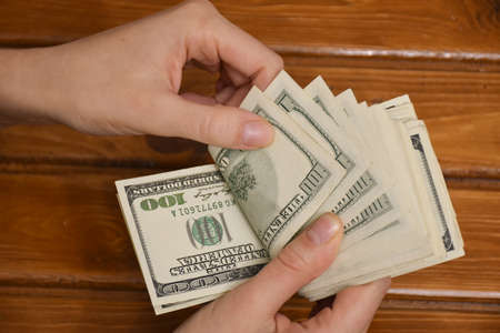 Woman hands counting us dollar banknotes