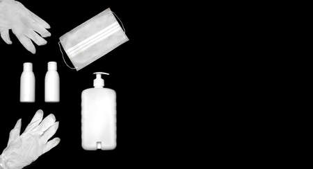 Top view of virus protection kit isolated on black background with copy space for text. Mask, rubber gloves, hand sanitizer bottles, antiseptic gel. Keep distance, be safe concept.の写真素材