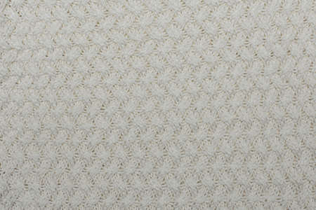 Knitted background, texture, pattern. Closeup of sample with knitting weave.