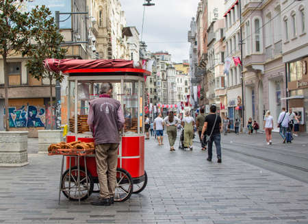 ISTANBUL, TURKEY - SEPTEMBER 10, 2019: Man sell traditional Turkish bagels (aka simit) in popular tourist place - Istiklal street, Beyoglu district, Taksim, Istanbul. Turkish street food.のeditorial素材