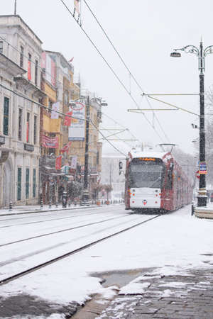 ISTANBUL, TURKEY - JANUARY 18, 2021: Modern tram is moving on the street in winter cold day with many snow. Snow storm in Turkey.のeditorial素材