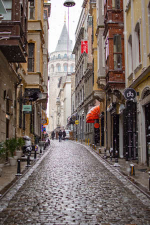 ISTANBUL, TURKEY - JANUARY 18, 2021: View of famous tourist place Galata tower from Serdar-I Ekrem street, Beyoglu district in winter day with snow.のeditorial素材