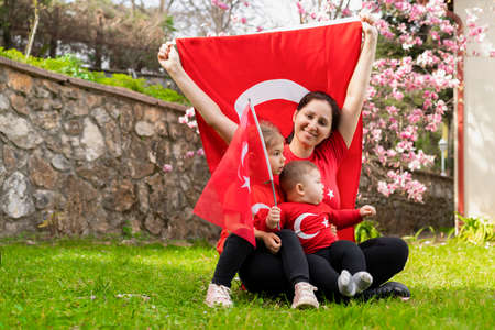 Mother and her son with a flag on the background of a blooming gardenの写真素材