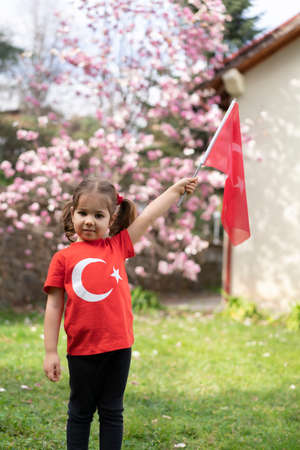 Cute little girl with Turkish flag in the garden. Selective focus.の写真素材